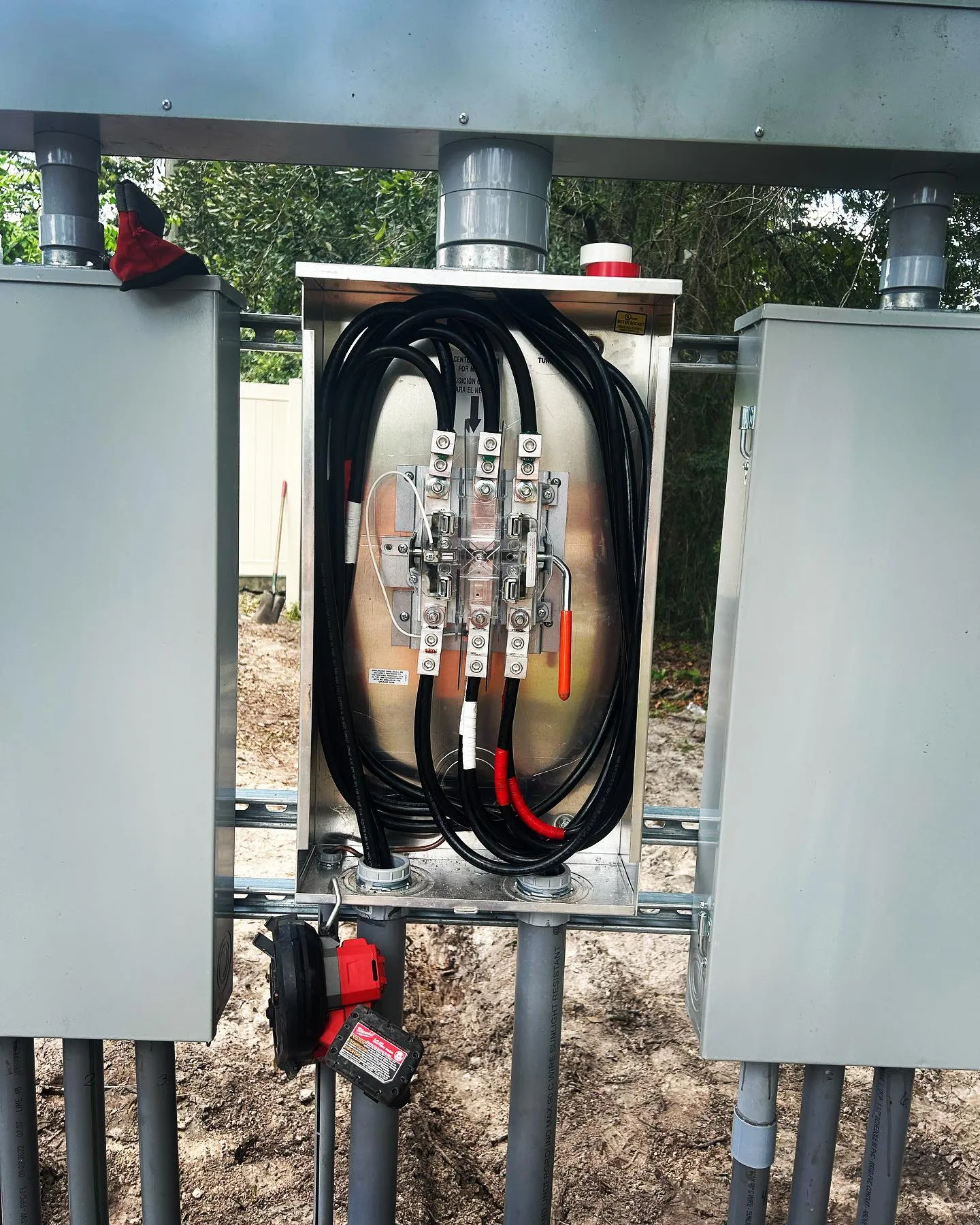 A new outdoor meter and disconnect installed between two gray enclosures